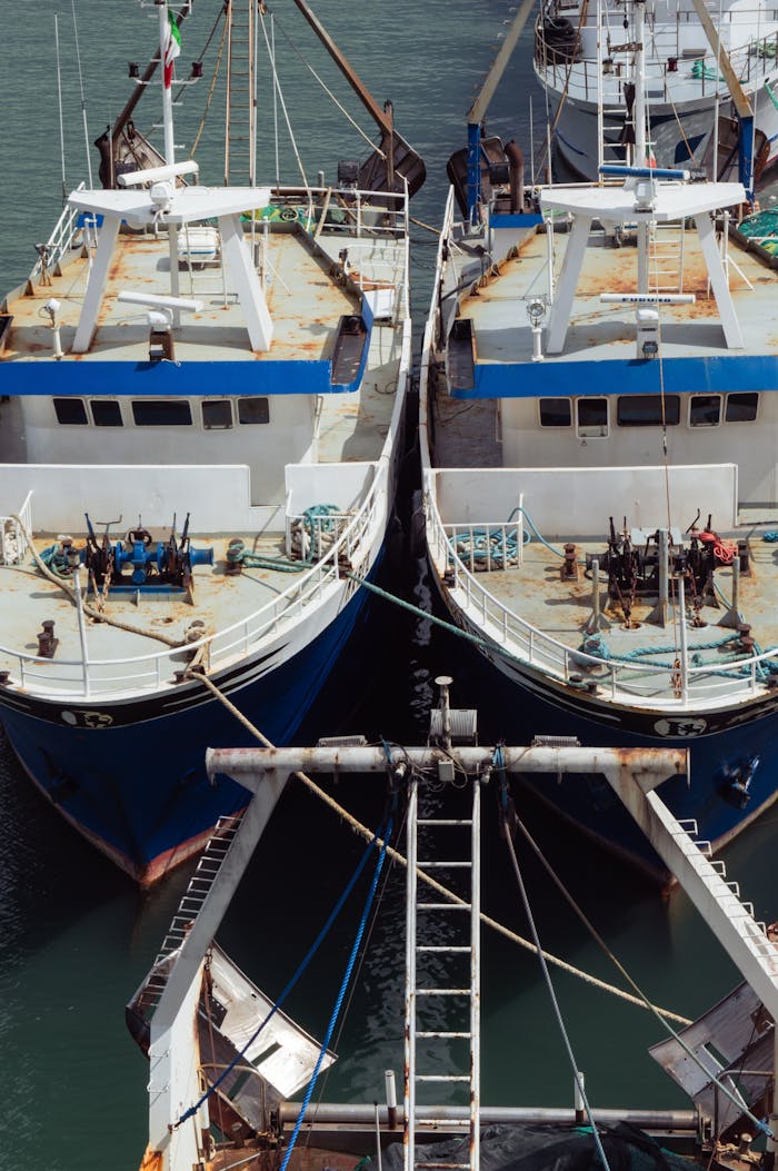 Overhead shot of two fishing boats moored side-by-side at the harbor.